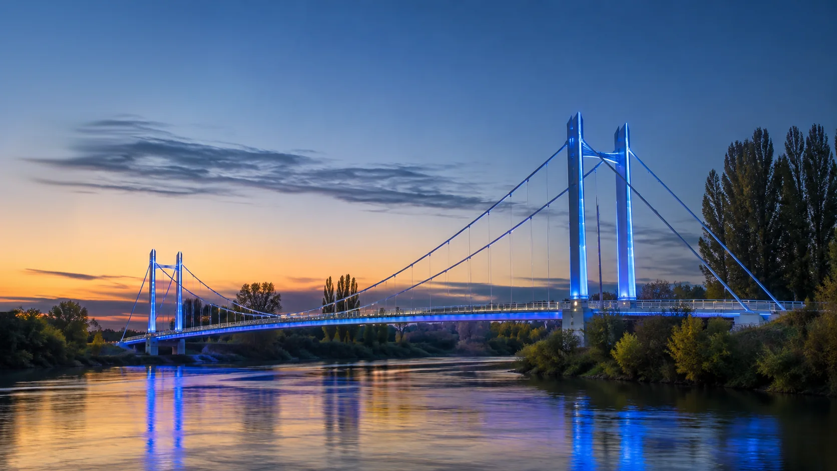 Le pont de Verdun-sur-Garonne éclairé en bleu au-dessus de la Garonne au petit matin